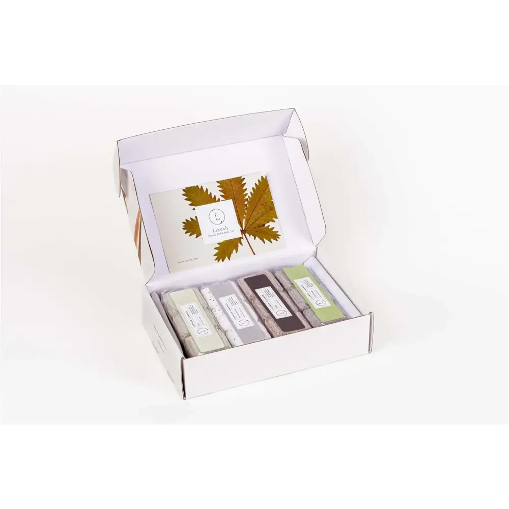 White cardboard gift box containing five rectangular soap bars in assorted neutral tones with minimalist labels.