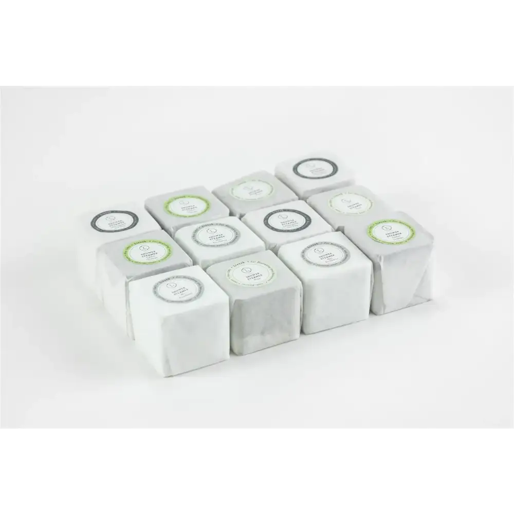 White cube-shaped tea boxes with minimalist circular labels in green and black.