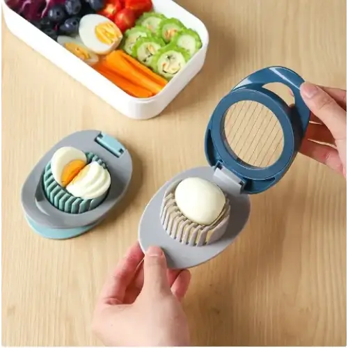 Blue and gray egg slicer with a circular blade and ridged base for neatly cutting hard-boiled eggs.