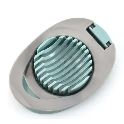 Teal and gray egg slicer with a circular, ridged cutting surface.