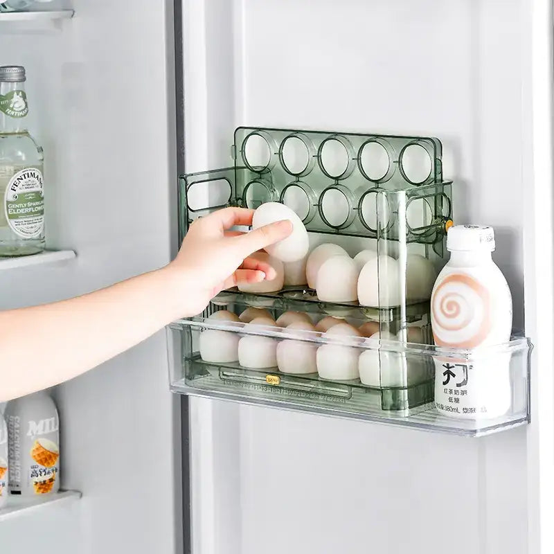 Transparent green plastic egg organizer with multiple compartments holding white eggs