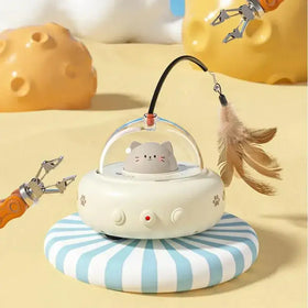 A cute gray cat-shaped toy in a transparent dome sits atop an off-white, paw-print decorated base with three buttons and a red indicator light.