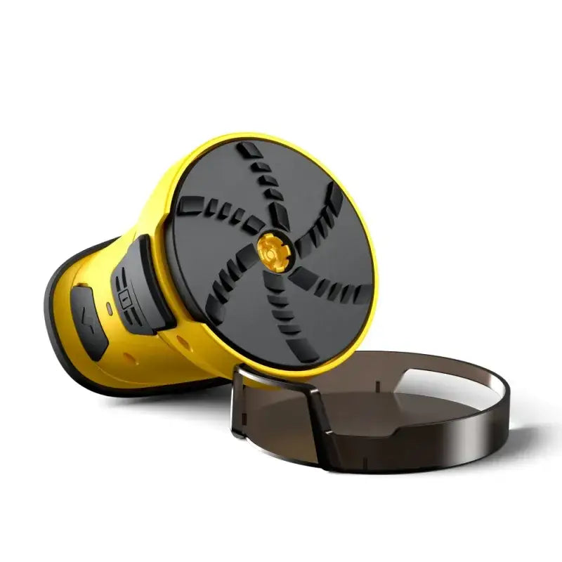 Yellow and black handheld device with a circular, textured top surface featuring a central golden accent.