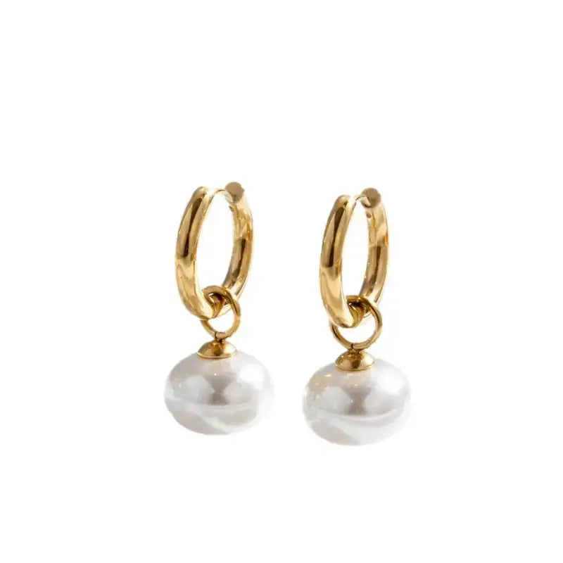 Gold hoop earrings with dangling white pearls.