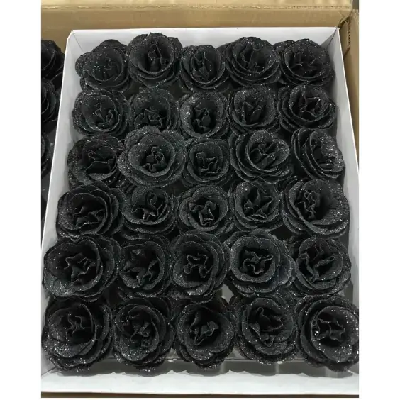 Black glittery foam roses arranged neatly in a white box.