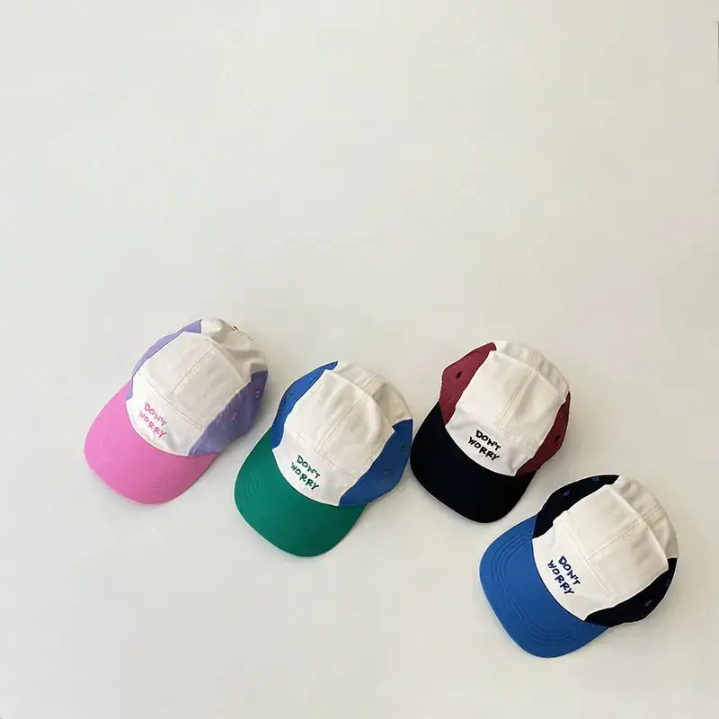 Colorful patchwork baseball caps with ’don’t worry’ embroidered in black on the front.