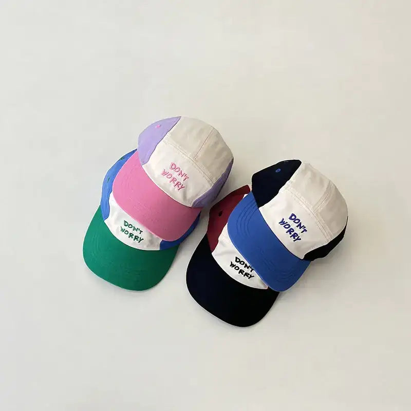 Pastel-colored panel cap with ’don’t worry’ embroidered in contrasting thread on a white front patch.