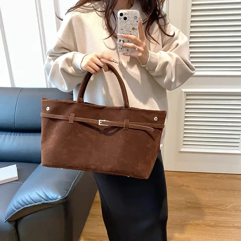 Brown suede tote bag with a matching leather strap and silver buckle.