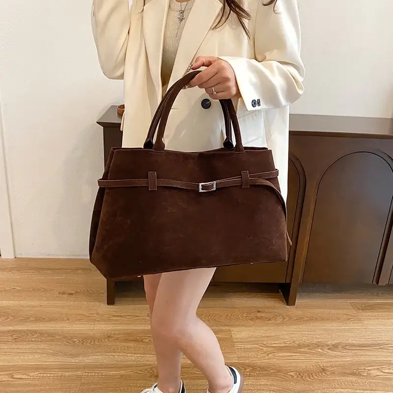 Brown suede tote bag with a silver buckle and matching handles.
