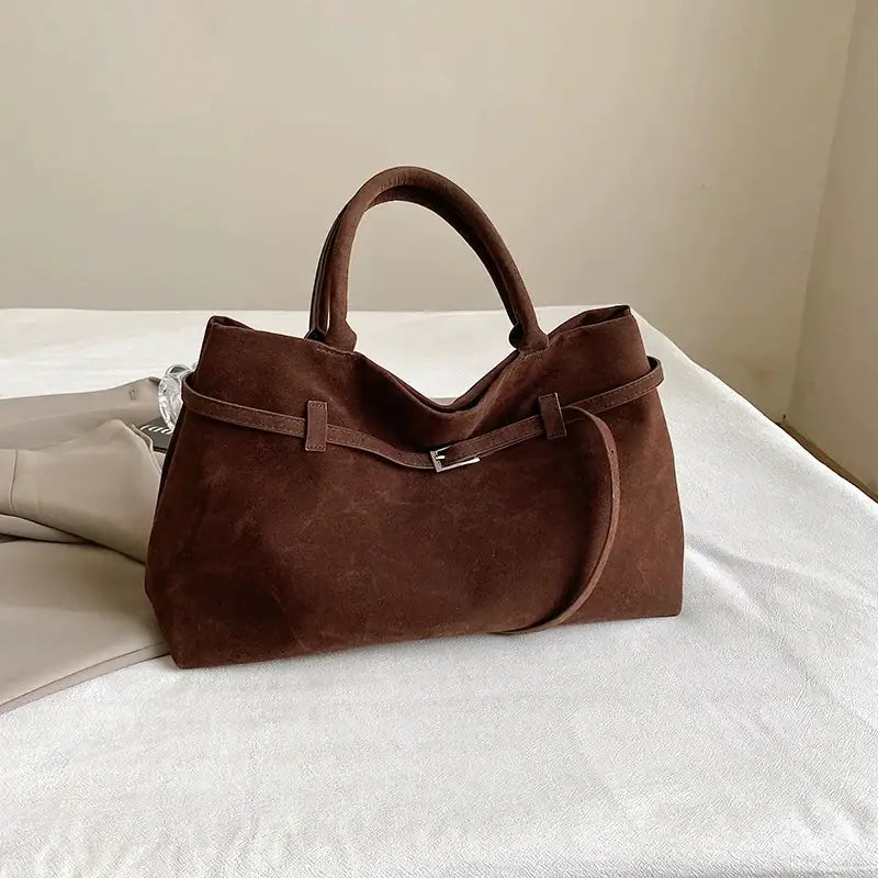 Brown suede tote bag with top handles and a detachable shoulder strap.