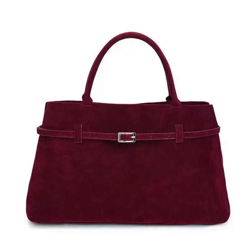 A rich burgundy suede handbag with a matching belt strap and silver-toned buckle.