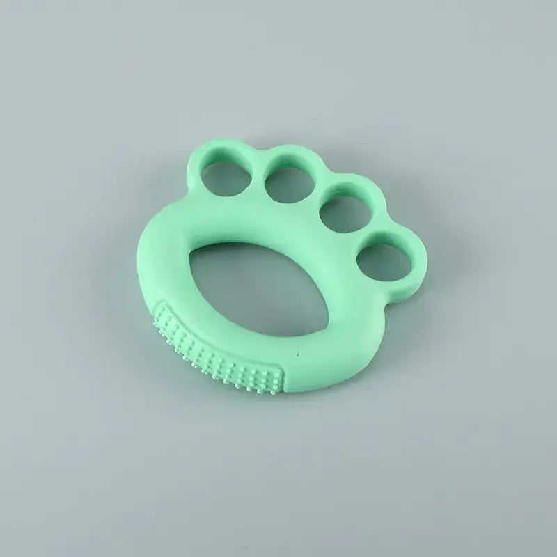 Mint green silicone baby teether shaped like a paw with textured grip on the underside.