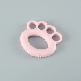 Pink silicone baby teether shaped like a paw print with textured ridges along the bottom edge.
