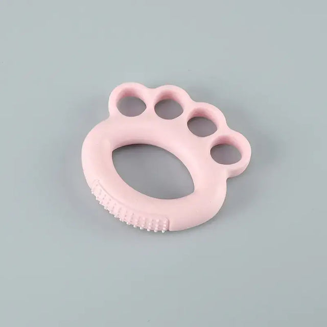 Pink silicone baby teether shaped like a paw print with textured ridges along the bottom edge.