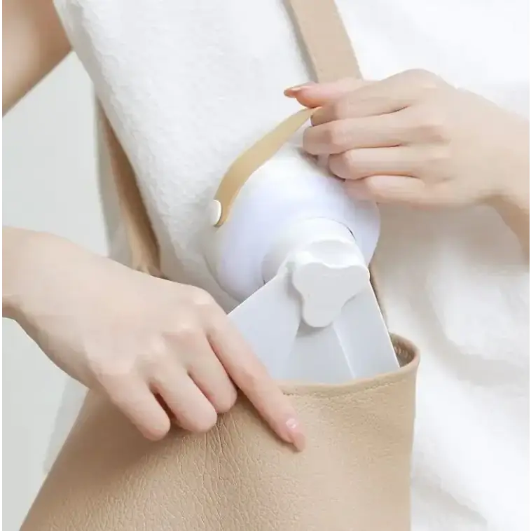 White plastic portable fan with a beige strap and a flower-shaped handle.