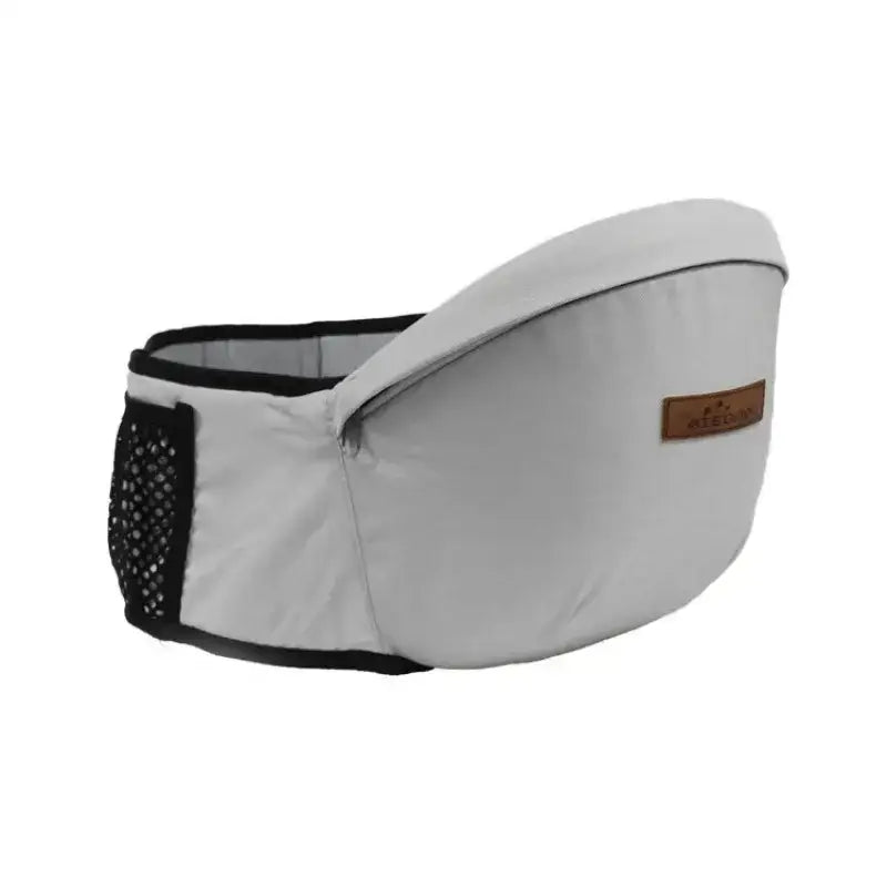 Light gray baby carrier with black trim and mesh side pocket, featuring a brown leather-like brand patch.