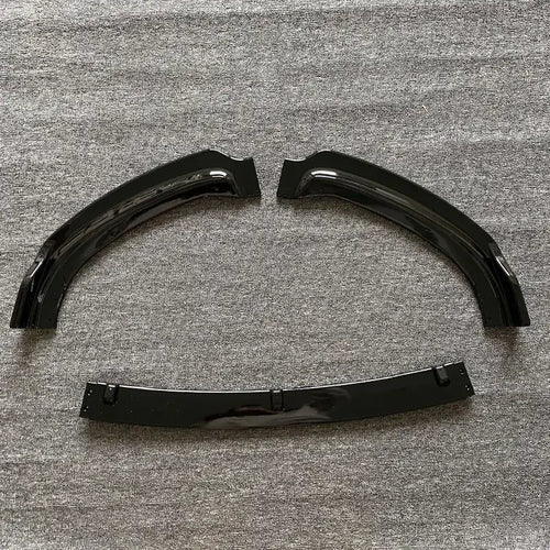 Black glossy plastic fender liners with a curved, arched design and mounting brackets.