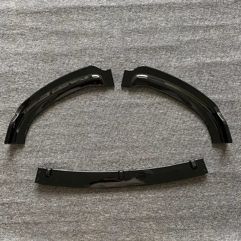 Black glossy plastic fender liners with a curved, arched design and mounting brackets.