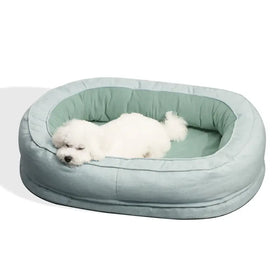 Soft, oval-shaped pet bed in a soothing light teal fabric with plush cushioning and a cozy interior lining.
