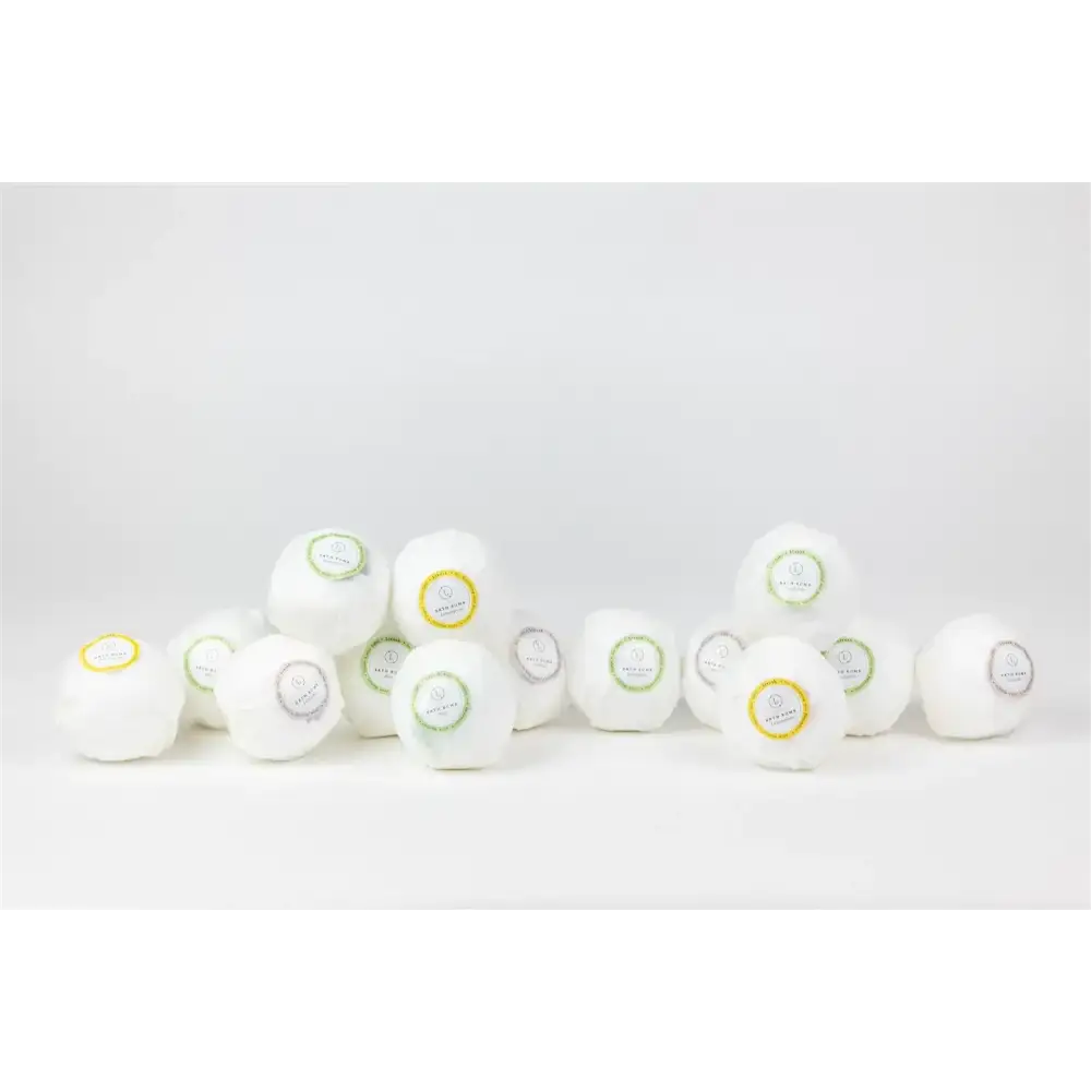 White spherical bath bombs with colorful circular labels.