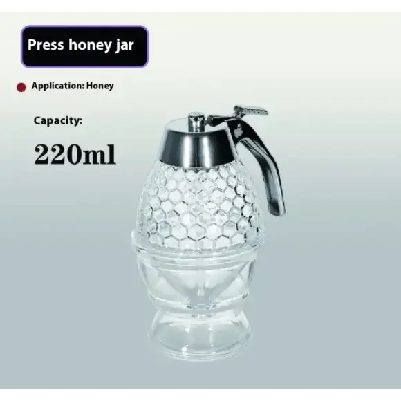 Clear glass honey press jar with a silver-toned metal handle and lid, featuring an intricate hexagonal pattern on its body.