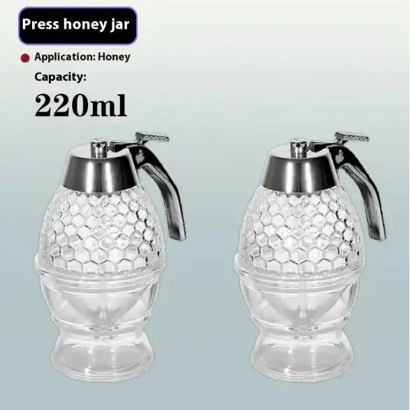 Clear glass press honey jar with a silver metal pump and handle, designed in a hexagonal pattern resembling a beehive.