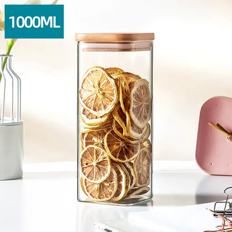 A clear glass storage jar with a bamboo lid, filled with dried lemon slices.