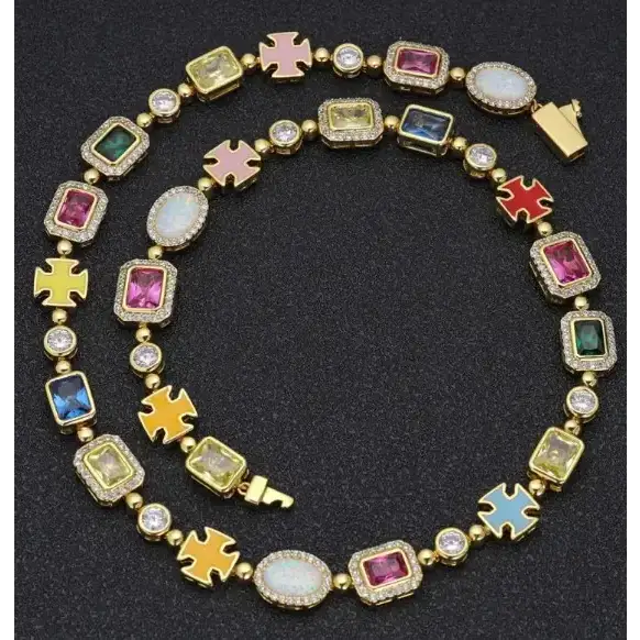 A vibrant, gold-toned necklace featuring colorful rectangular and oval gemstones in pink, blue, green, yellow, and white opal, accented with small clear crystals.