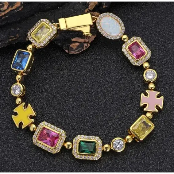 A vibrant, gold-toned bracelet featuring colorful rectangular and oval gemstones set in a pave design with pink cross charms.
