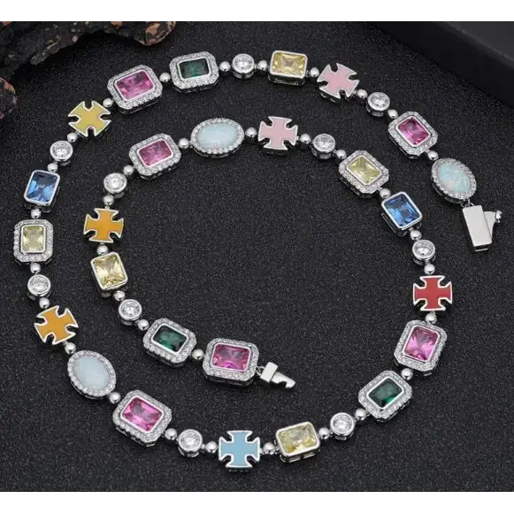 A vibrant, multi-colored necklace featuring a series of rectangular and oval-shaped gemstones in pink, blue, yellow, green, and white, set within silver-toned metal frames adorned with small clear crystals.