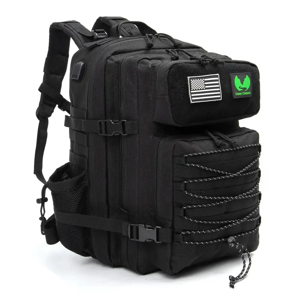 Black tactical backpack with reinforced straps, multiple compartments, and a green ’green canyon’ patch on the top flap.