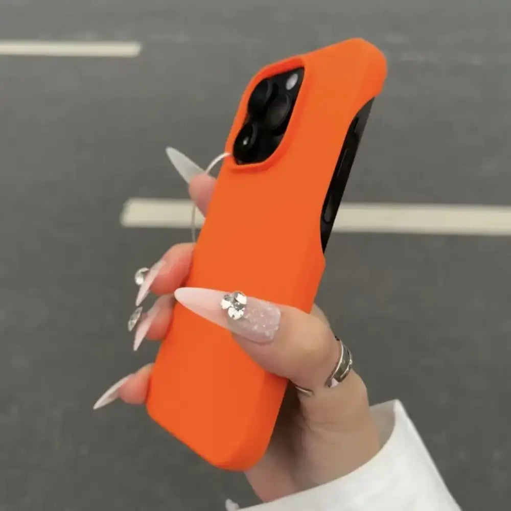 Bright orange silicone phone case with a matte finish, snugly fitted over an iphone 13 pro.