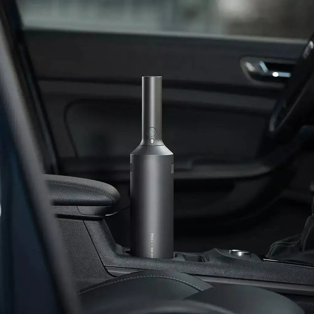 A sleek, matte black handheld car vacuum with a cylindrical body and a narrow nozzle.
