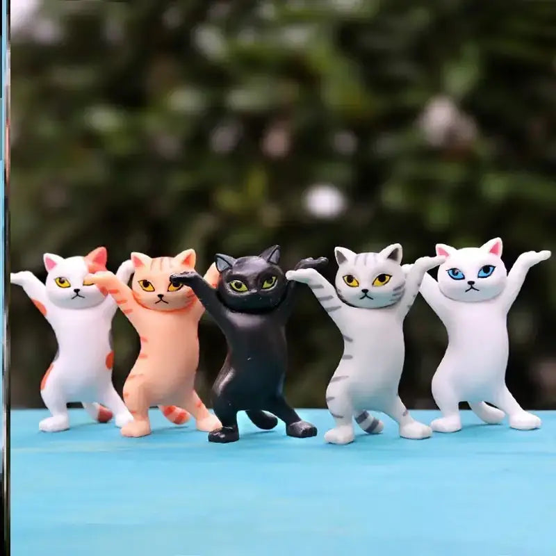 A set of five colorful, glossy plastic cat figurines in dynamic dance poses.