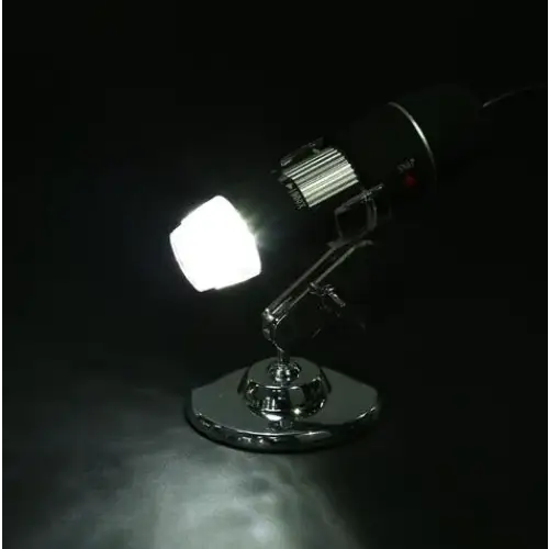 A sleek, black and chrome desktop microscope with a bright white led light illuminating the sample area.