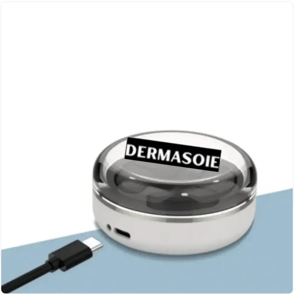 A sleek, round dermasoie portable charger with a transparent dome lid and metallic silver base.