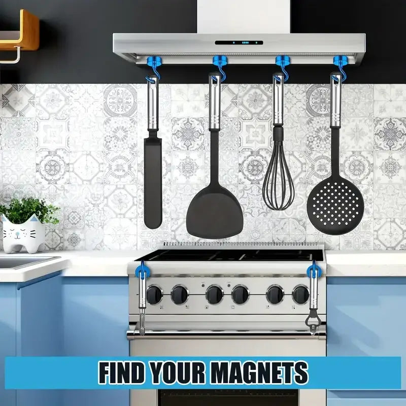 Set of black silicone-coated kitchen utensils with stainless steel handles, hanging from blue magnetic hooks attached to a range hood and stove.