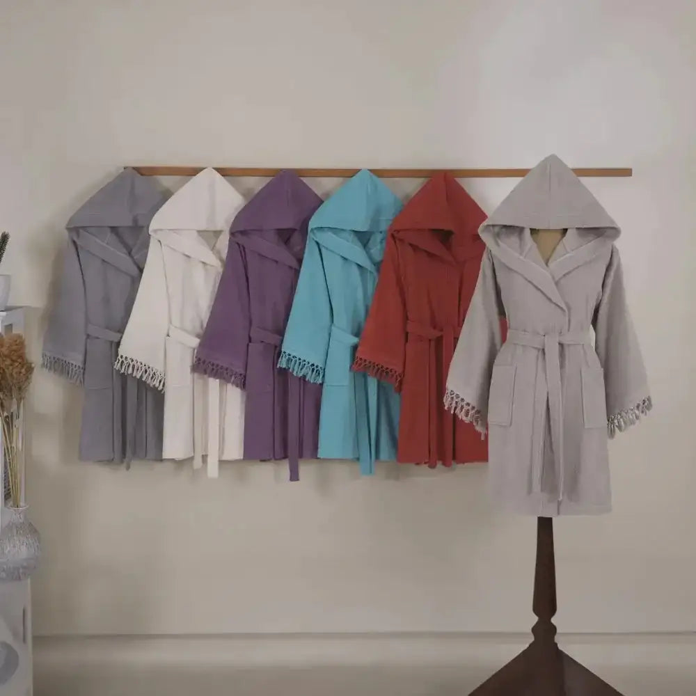 A soft, plush gray hooded robe with a matching belt and decorative fringe along the cuffs and hem.