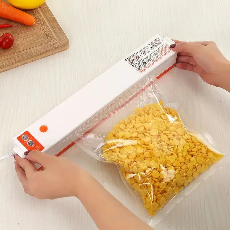 White and orange handheld vacuum sealer with a clear plastic bag filled with yellow cornflakes being sealed.