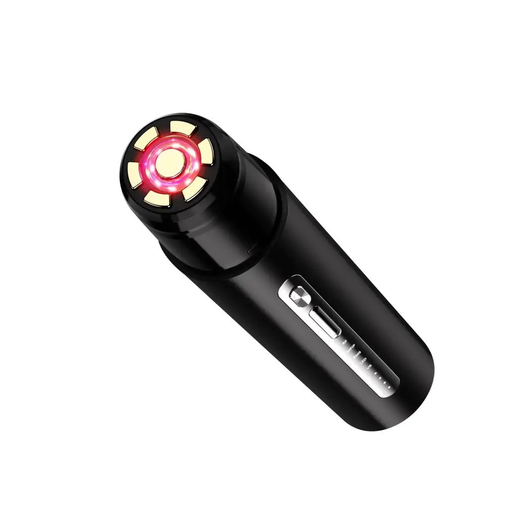 Black handheld facial device with a glowing red and gold circular light head.