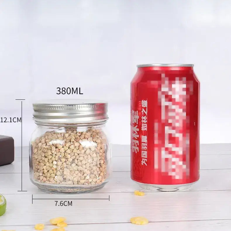 Clear glass jar with a silver metal lid, filled with light brown buckwheat grains.