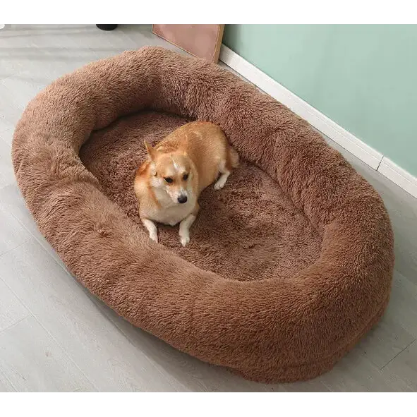A cozy, plush brown dog bed with a soft, fluffy texture and an oval shape.