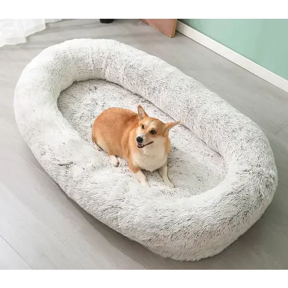 A cozy, oval-shaped pet bed with a plush, fluffy gray faux fur exterior and soft inner lining.