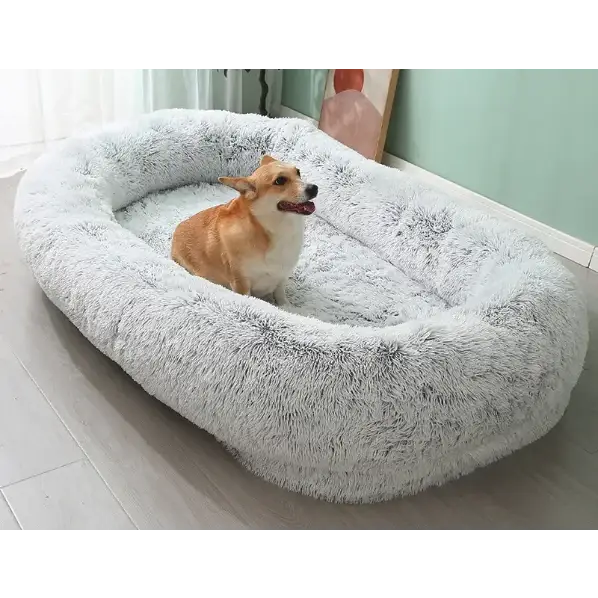 Soft, plush gray faux fur dog bed with a cozy, oval shape and raised edges.