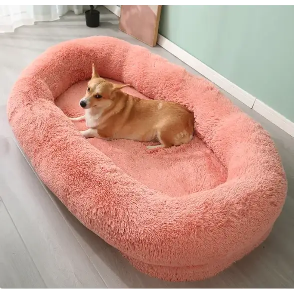 Pink plush oval dog bed with soft, fluffy texture and cozy interior.