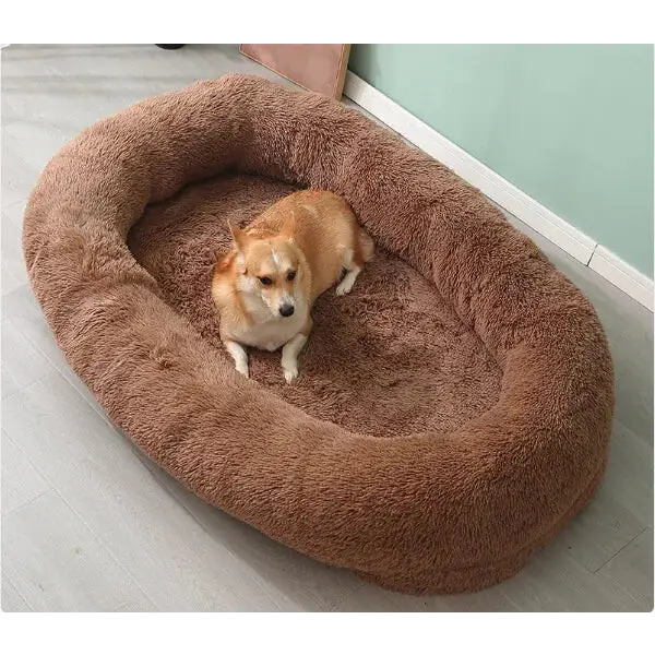 A plush, oval-shaped brown dog bed with a soft, fluffy texture.