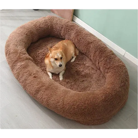 A plush, oval-shaped brown dog bed with a soft, fluffy texture.
