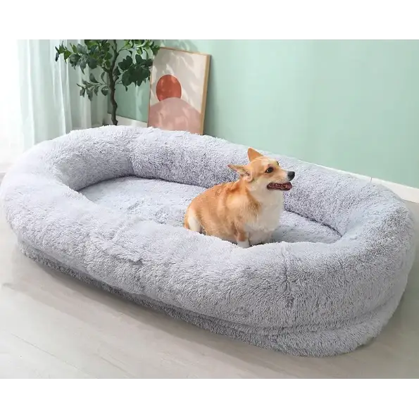 Soft, plush gray dog bed with a cozy, oval shape and high, cushioned edges.