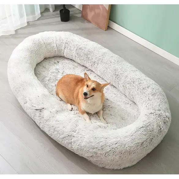 Soft, plush gray faux fur dog bed with a cozy oval shape and raised edges.