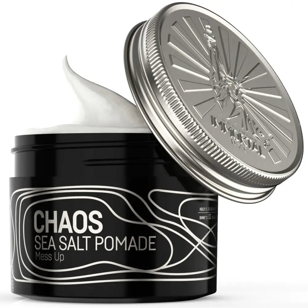 Black cylindrical jar with silver lid, featuring ’chaos sea salt pomade’ in white text on a sleek label.